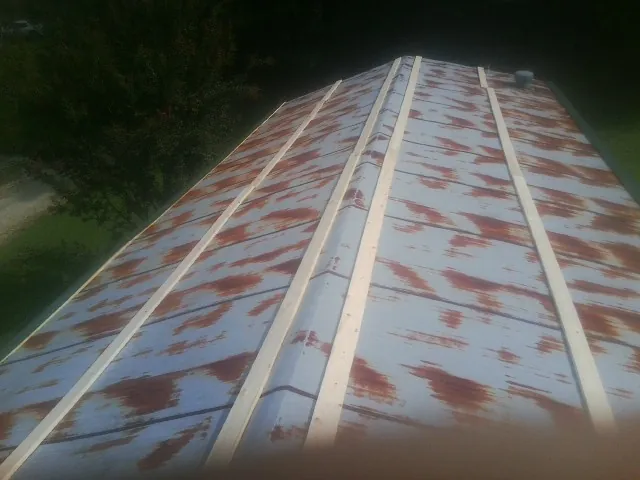 Rusted metal roof panels with new wood purlins before replacement — Storm Damage Roof Repair in Gilford by Roofing Brothers